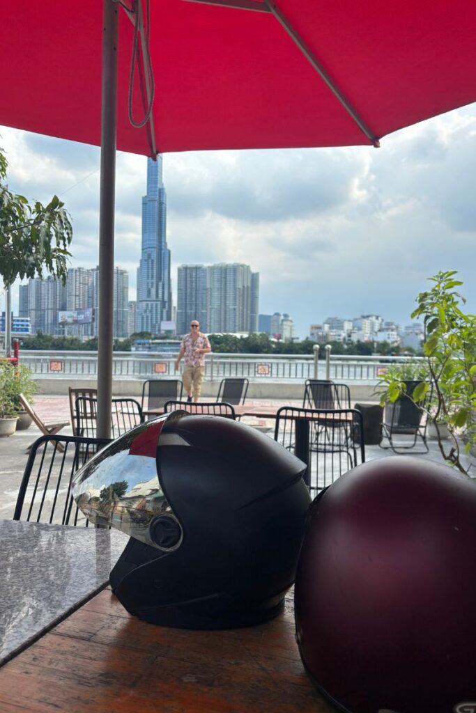 Two motorbike helmets rest on a table at a cafe in Ho Chi Minh City, a quieter moment while traveling through Vietnam and staying alert for scams in Vietnam.