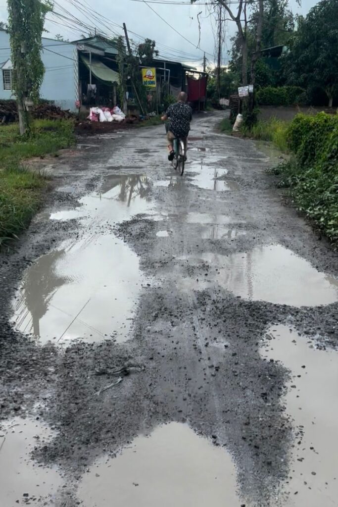 Biking through rainy puddles in Mekong region during rainy season in Ho Chi Minh City