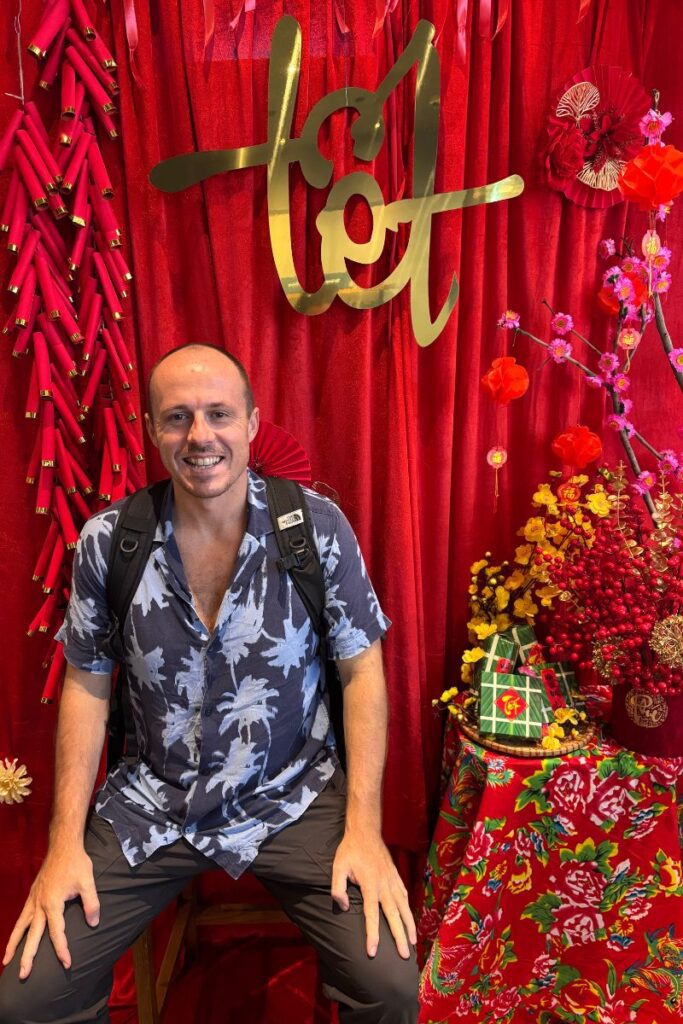 Garrett sitting in front of Tet decorations