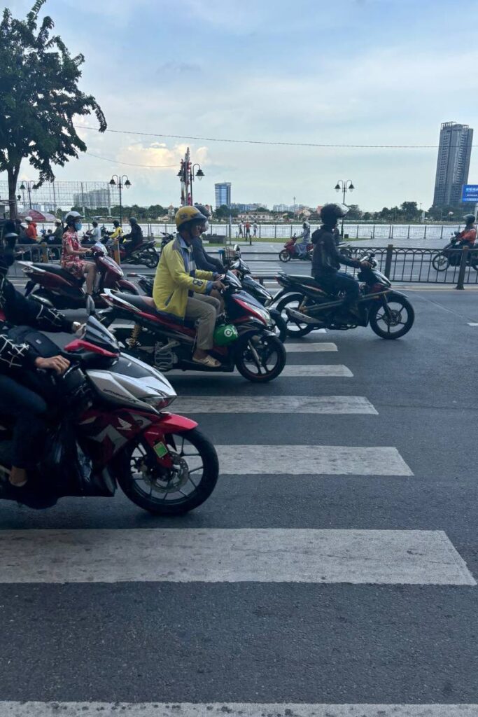 "Motorbikes crossing a busy intersection at a green light in Ho Chi Minh City, showing the lively streets you experience with things to do in HCMC.