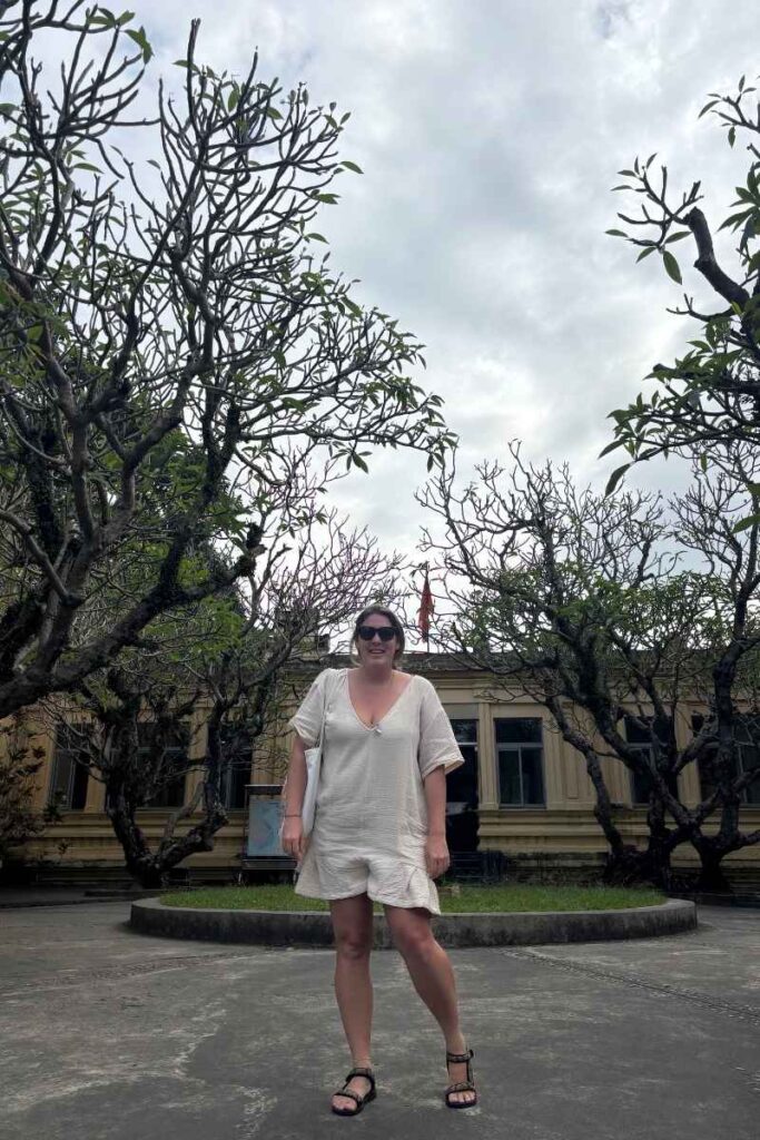 Standing outside the Cham Sculpture Museum in Da Nang, surrounded by leafless trees and historic architecture, a top cultural stop for those wondering what to see in Da Nang.