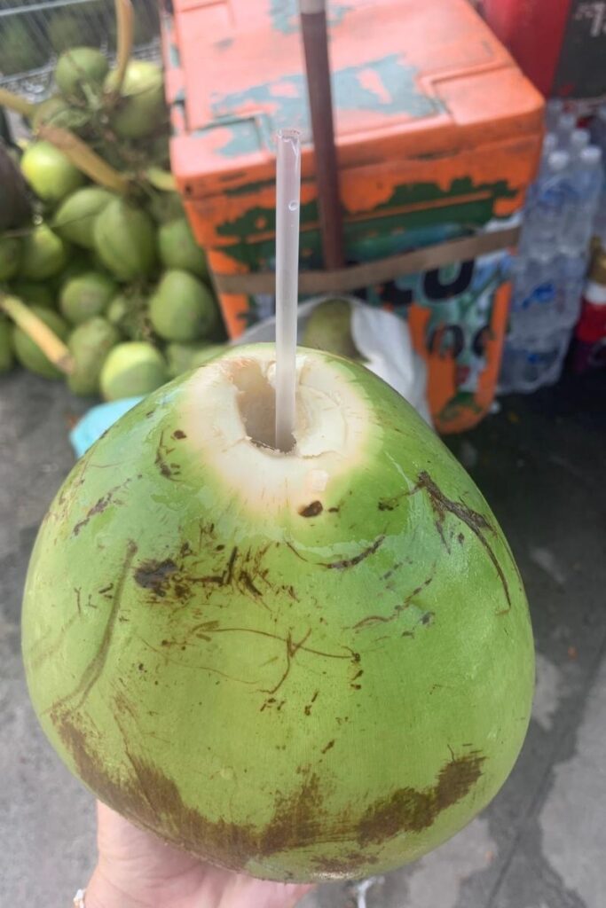 A fresh coconut with a straw ready to drink, a reminder of how tourists can sometimes encounter coconut-related Vietnamese scams.