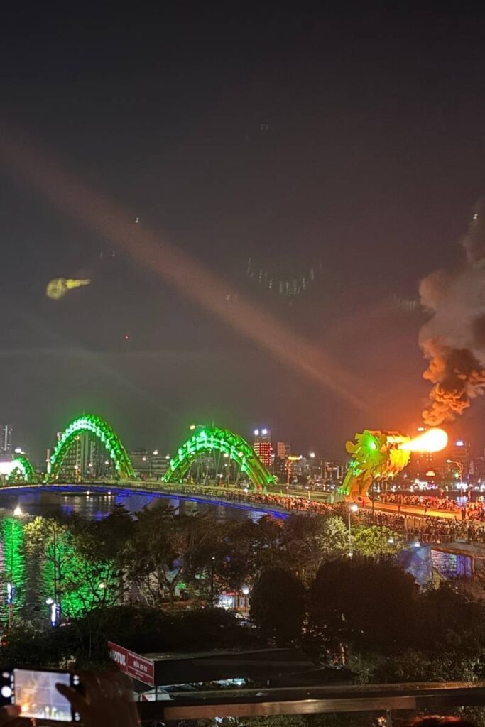 The Dragon Bridge in Da Nang lit up at night with its iconic fire show, as crowds gather to experience one of the best things to do in Da Nang and a highlight among Da Nang city activities.