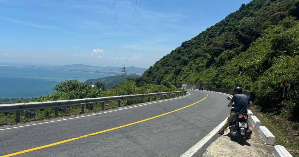 Motorbike on the Hai Van Pass road near Da Nang with ocean views and lush hillsides.