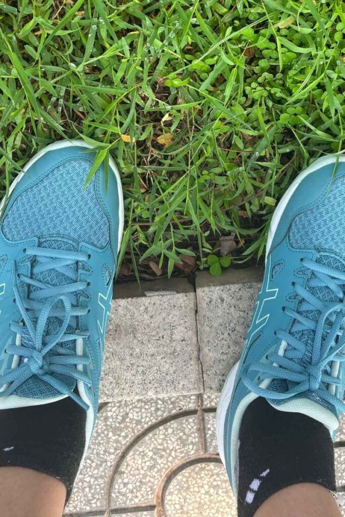 Close-up of blue sneakers on a sidewalk in Vietnam, where tourists are sometimes targeted by shoe-cleaning Vietnamese scams.