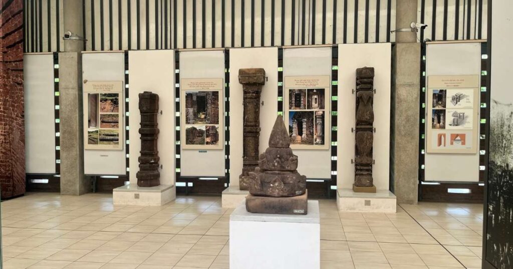 nterior view of the My Son Museum showcasing Cham-era stone pillars, architectural fragments, and informational panels about temple construction.
